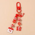Detail eines roten Perlen-Schlüsselanhängers mit Love- und Valentinstag-Anhänger - Geschenkbox Kalender Stil