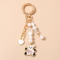 Detail of beaded keychain with white enamel bear pendant and faux pearl charms - White