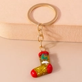 Festive red glitter Christmas stocking keychain with green tree detail and golden hardware - Red and White Enamel Christmas Sock
