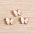 Dettaglio macro di tre ciondoli a farfalla in oro rosa con smalto rosa per gioielli fai da te - Smalto Rosa Pallido (YD005fense)