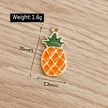 Detail view of a 26mm enamel pineapple charm on wood with size and weight dimensions - Pineapple