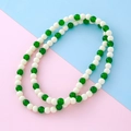 Collier élégant avec perles vertes style jade et blanches mates sur fond pastel bicolore - Collier
