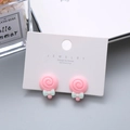Cute pink swirl lollipop earrings with green ribbon bows on white jewelry card - Lollipop