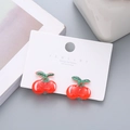Cute red cherry resin clip-on earrings for girls with green leaf details on display card - Cherry