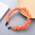 Orange ruffled organza headband with elegant puffy design on a minimalist background - Orange