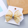 Fermaglio per capelli con fiocco in rete dorata e pizzo bianco per bambine su carta - Sfondo bianco con oro