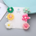 Set mit 6 bunten Gänseblümchen-Haarspangen in lebhaften Bonbonfarben auf Displaykarte - Blume