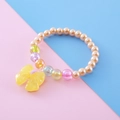Kids beaded bracelet featuring cream orange pearls and a bright yellow resin bow pendant - Champagne