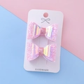 Pink glitter bow hair clips for girls featuring holographic layers on display card - Pink