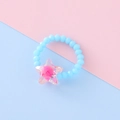 Anello elastico per bambini con perle azzurre e un ciondolo a stella rosa in resina - Stile Stella / Celeste