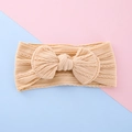 Soft beige knit baby headband featuring a large bow and classic cable stitch texture - Beige