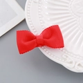 Red bow hair clip with ribbed texture on a white decorative ceramic plate - Wavy Edge Bow Hair Clip