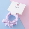Elastic purple bow hair tie for girls featuring textured fabric on a display card - Light Purple