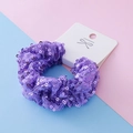 Chouchou à paillettes violettes avec emballage décoratif sur fond de couleur pastel - Style Pailleté Violet