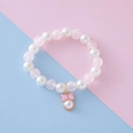 Kids beaded bracelet with white faux pearls and pink enamel bow pendant charm - White