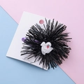 Halloween ghost hair clip with black pom poms and purple base on display card - Ghost