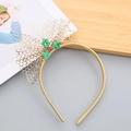 Close-up of Christmas headband with golden mesh bow and holly berries on a wooden tray - Gold Headband