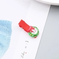 Detalle de una pinza para el pelo navideña de cinta roja con una corona festiva verde - Pinza Guirnalda Navidad
