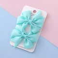 Pair of light blue solid color grosgrain ribbon bow hair clips on handmade card - Lake Green
