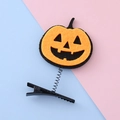 Cute Halloween hair clip featuring a smiling orange pumpkin on a flexible black spring base - Pumpkin Smiley Style