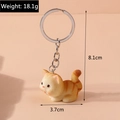 Detalle de un lindo llavero de gato naranja con dimensiones precisas e información de peso - Gato