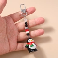 Detail of cute 3D penguin keychain featuring colorful beads and a silver metal clasp - Penguin