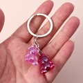 Detail view of cute purple and wine red gummy bear charms on a silver keychain - Rose Purple