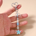 Dettaglio del portachiavi a tema marino con medusa blu, perline a righe e stella marina - Blu