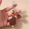 Detail of beaded star keychain featuring a faux chocolate ice cream and milk bar charm - Brown