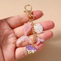 Detalle de llavero con tema marino con cola de sirena rosa y corazón de perlas - Morado