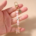 Vue détaillée d'un porte-clés perlé avec cœurs roses et breloques cactus alpaga - Cactus Lama Rose