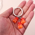 Detailed shot of three gradient orange-red resin bears on a silver metal keychain hook - Gradient Bear Style / Orange Red