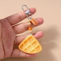 Dettaglio portachiavi a forma di waffle con perle arancioni e chiusura argento - Pane Biscotto Triangolare