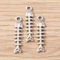 Detailed macro view of vintage silver fishbone charms for DIY jewelry and necklaces - 30Pcs Pack / Fishbone
