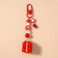 Détail d'un porte-clés de Noël avec pendentif boîte cadeau rouge et perles de fête - Style Boîte Cadeau