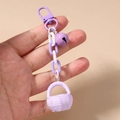 Detail of purple woven basket charm with matching chain and bell on a metal clasp - Purple