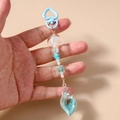 Dettaglio del portachiavi blu tema oceano con chiusura a cuore, conchiglia e perline - Celeste