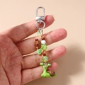 Dettaglio di un portachiavi a forma di lumaca verde con perline colorate sulla spilla - Verde