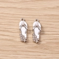Macro detail of silver flip-flop charms with rhinestones and pearl for DIY jewelry - Silver