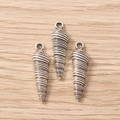 Macro detail van drie zilveren schelpbedels met vintage spiraaltextuur op hout - Schroef