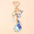 Dettagli del coniglio in smalto blu e della margherita su un portachiavi a cuore oro - Fiore Coniglio Triangolo