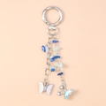 Close-up of butterfly keychain with blue turquoise beads and faux pearl charms - Blue Butterfly Turquoise