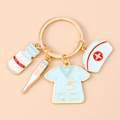 Macro shot of nurse-themed keychain with enamel pill bottle and thermometer charms - Blue Nurse Uniform Hat Drip
