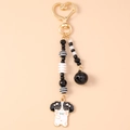 Détail du fermoir cœur doré et pendentif chien en émail avec des perles noires et blanches - Chien Noir