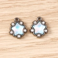 Detail showing two star-shaped pendants with opal stones and crystals on wooden background - 5 Pieces / Grey Blue
