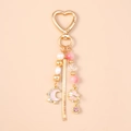 Detail view of heart-shaped keychain with pink pearls, moon pendant and metal tassels - Moon Star Pearl