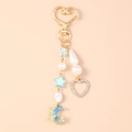 Detail of gold heart clasp with pearl beads and blue star charm on a stylish keychain - Heart Moon Pearl