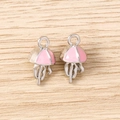 Close-up of silver-plated jellyfish pendants with pink enamel on a wooden surface - Silver Pink
