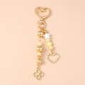Detailed view of a golden heart keychain with pearl beads and star-shaped charms - Star Heart