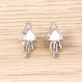 Detail of two silver jellyfish pendants with tentacles and loops on wooden background - Silver
